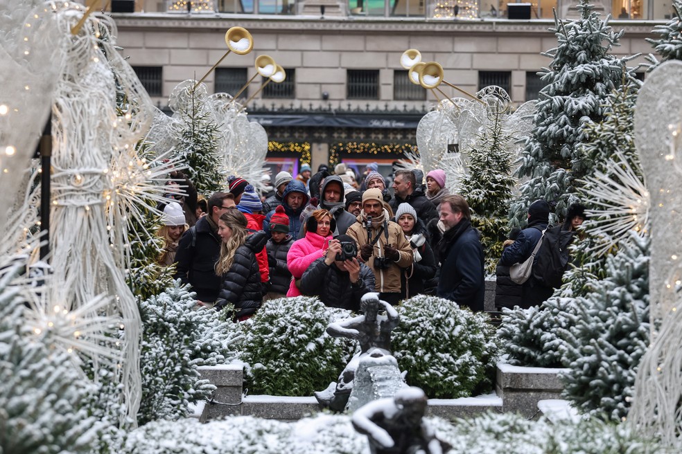 Turistas enfrentam o frio para fotografar os enfeites de Natal em Nova York nesta terça-feira (24) — Foto: Marko Djurica/Reuters