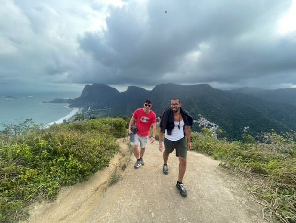 Britânicos na trilha do Dois Irmãos, com a Pedra da Gávea e a Praia de São Conrado ao fundo — Foto: Arquivo pessoal