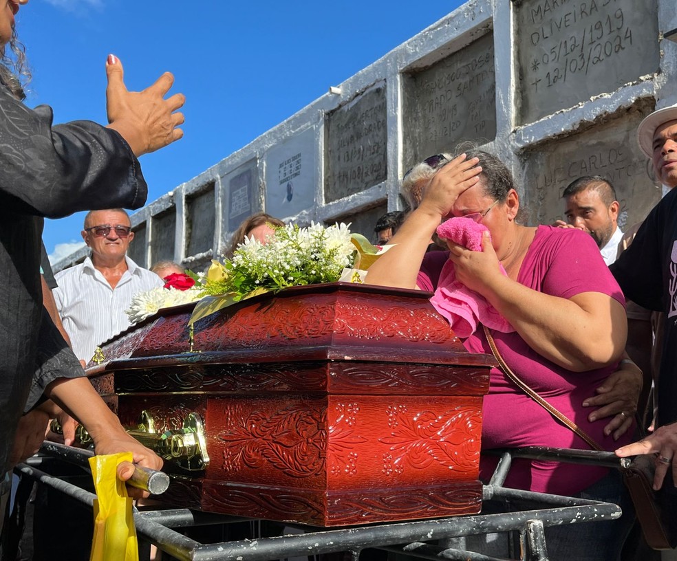 Filha de Maria Feliciana, Chirles Santos, se emociona durante sepultamento do corpo da mãe. — Foto: Leonardo Barreto