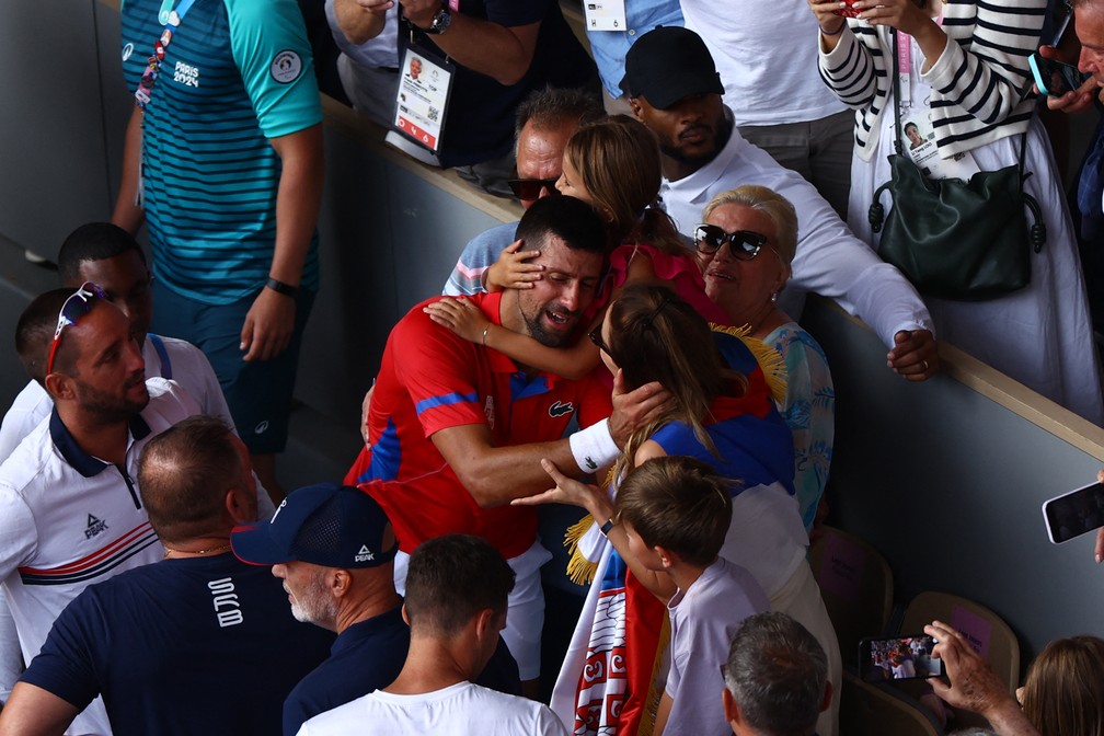 O sérvio Novak Djokovic se emociona comemorando com a família após conquistar o ouro do tênis individual sobre Carlos Alcaraz nas Olimpíadas de Paris 2024 — Foto: Edgar Su/Reuters