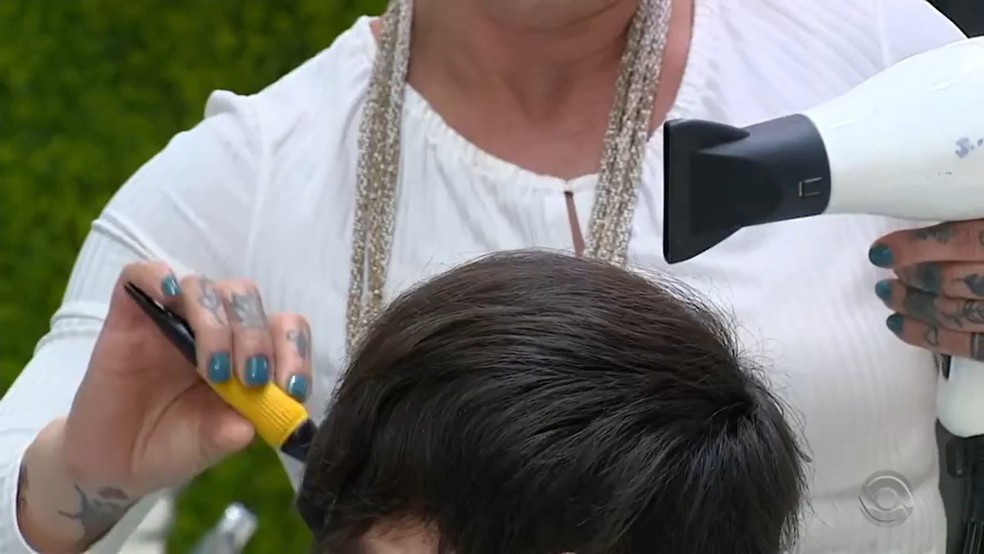Cabeleireira manuseia secador de cabelo. — Foto: Reprodução/RBS TV