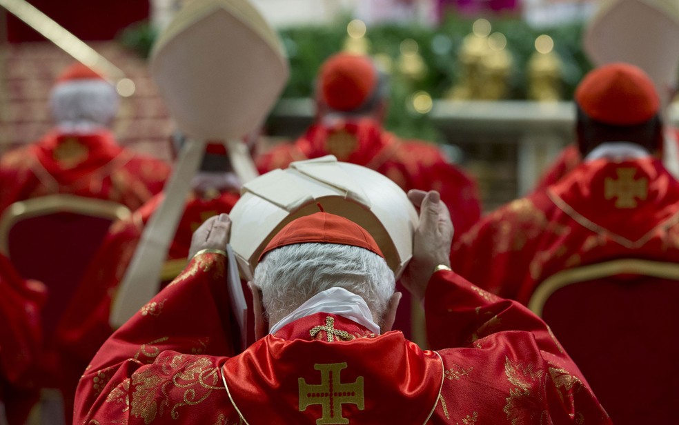 Cardeal coloca sua mitra durante a missa do início do conclave — Foto: Andrew Medichini/AP