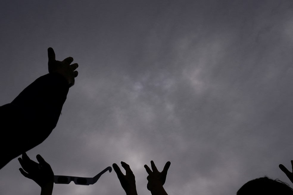Pessoas torcendo para que as nuvens se dissipem e permitam a observação do eclipse total no Dunkirk Lighthouse & Veterans Park Museum, em Dunkirk, Nova York. — Foto: Reuters/Elizabeth Frantz
