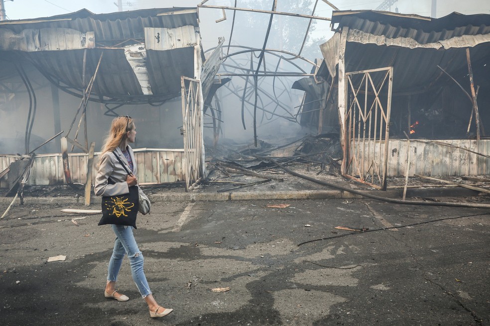 Moradora de Kiev passa por mercado destruído por ataque russo à cidade em 30 de julho de 2026 — Foto: Alina Smutko/Reuters