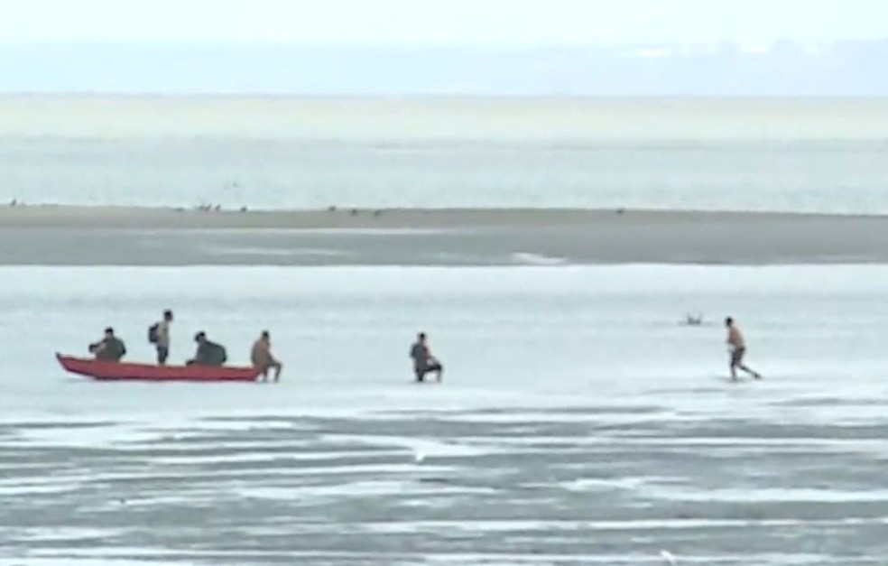 Passageiros precisaram usar uma canoa após o barco ficar preso na maré baixa em São Luís. — Foto: Reprodução/TV Mirante