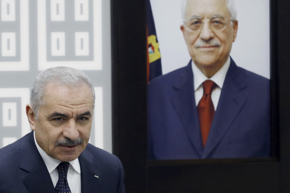 O primeiro-ministro palestino, Mohammad Shtayyeh, ao lado de um retrato do presidente da Autoridade Palestina, Mahmud Abbas, durante reunião de gabinete anunciou renúncia — Foto: Zain Jaafar/AFP