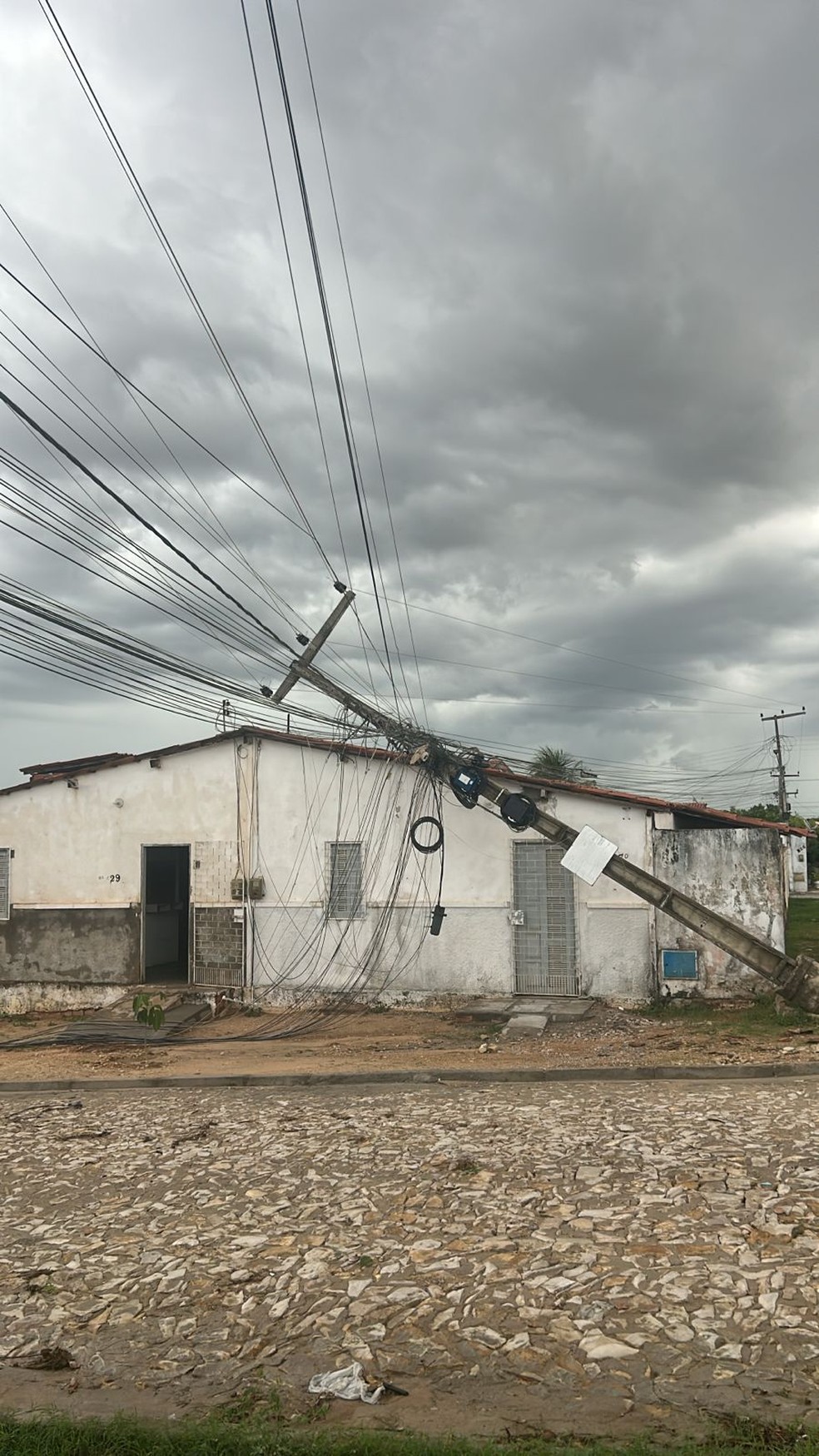 Poste cai sobre casa após fortes rajadas de vento em Russas, no interior do Ceará — Foto: Reprodução