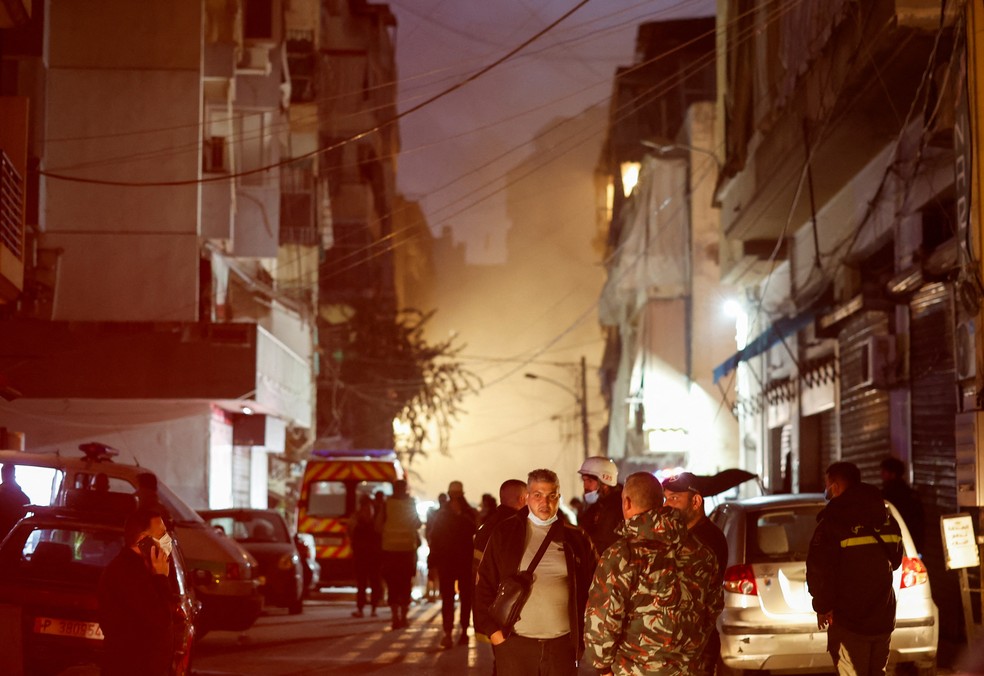 Pessoas se reúnem no local de um ataque israelense no bairro Basta, em Beirute, neste sábado (23) — Foto: Adnan Abidi/Reuters