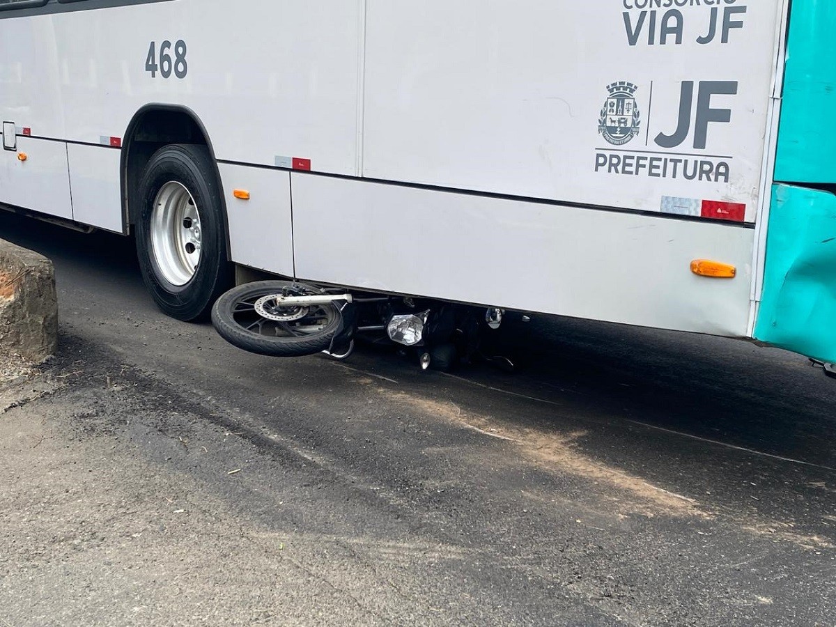 Moto para embaixo de ônibus após acidente na Avenida JK, em Juiz de Fora