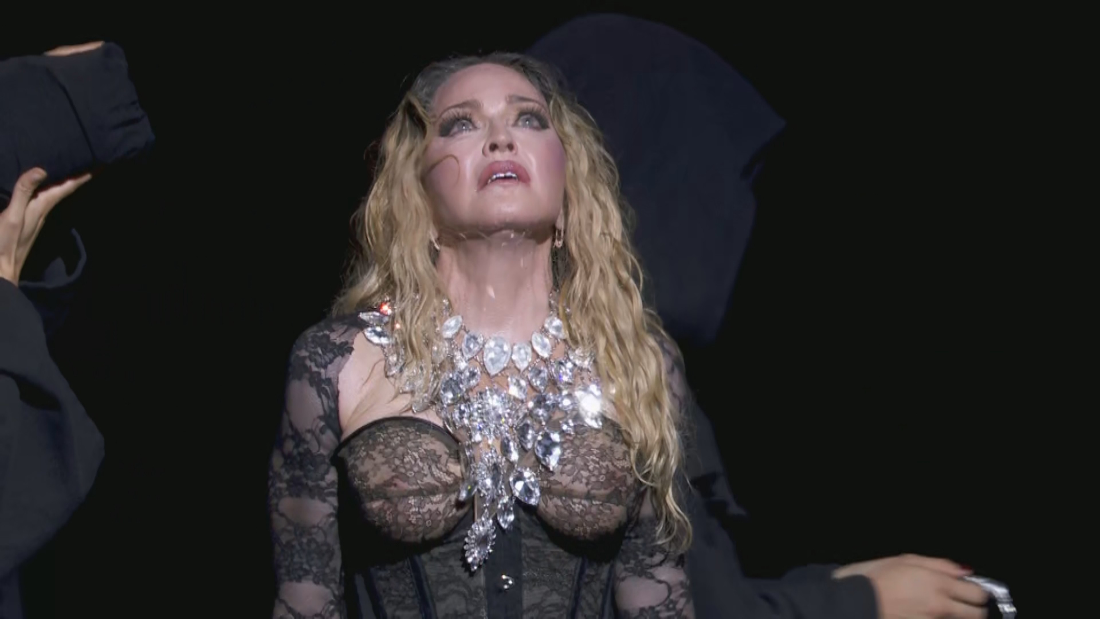 Madonna chora em Copacabana durante homenagem a mortos por Aids; Renato Russo aparece no telão