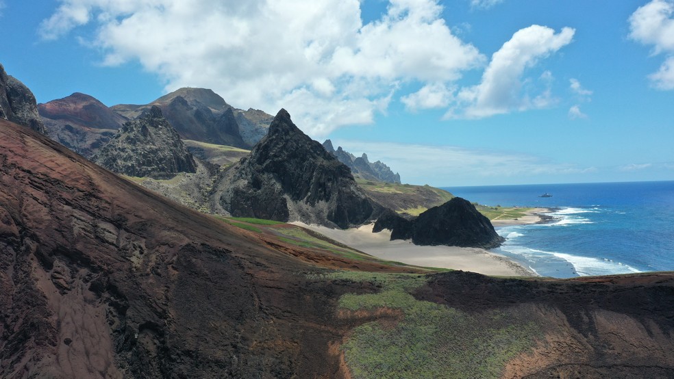 Parcel das tartarugas, praia na Ilha da Trindade, vista de longe, com composições rochosas ao fundo. — Foto: Reprodução/Yara de Mello