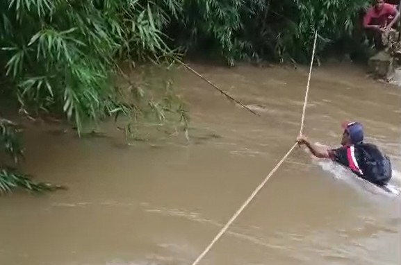 VÍDEO: Moradores se arriscam ao atravessar rio com corda após ponte ser levada pela correnteza 