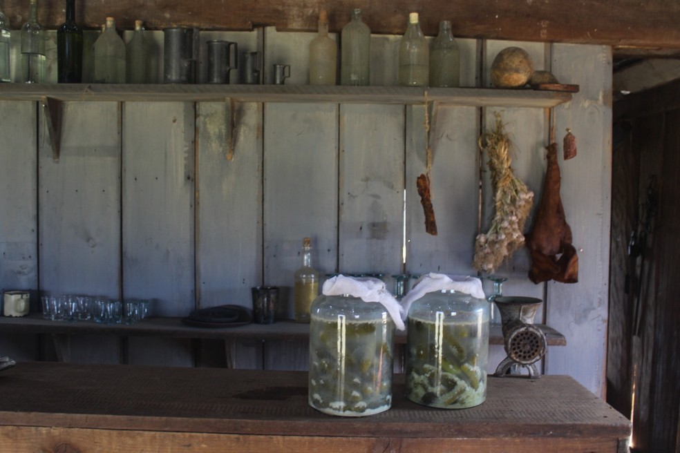 Potes de conservas e outros produtos na ambientação da vila — Foto: Mariah Colombo/g1