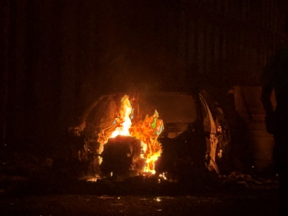 Um carro em chamas no leste de Belfast , durante um protesto após um ataque com faca em 8 de junho que deixou um homem gravemente ferido e levou a polícia a declarar estado crítico, em Belfast , Irlanda do Norte — Foto: Isabel Infantes / Reuters