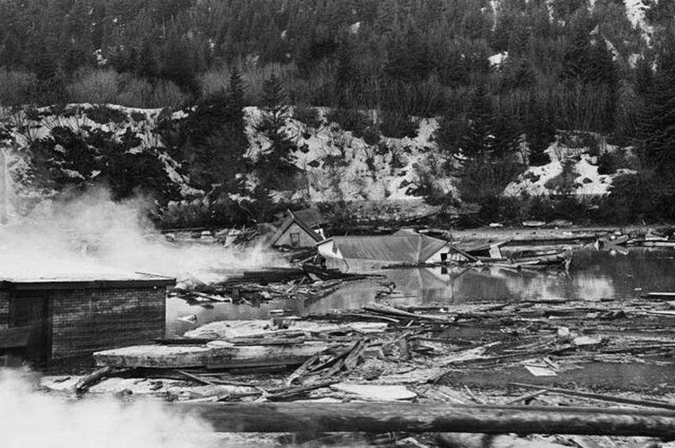 Fumaça de restos de tanques de óleo entre ruínas de casas após terremoto e maremoto no Alaska — Foto: GETTY IMAGES
