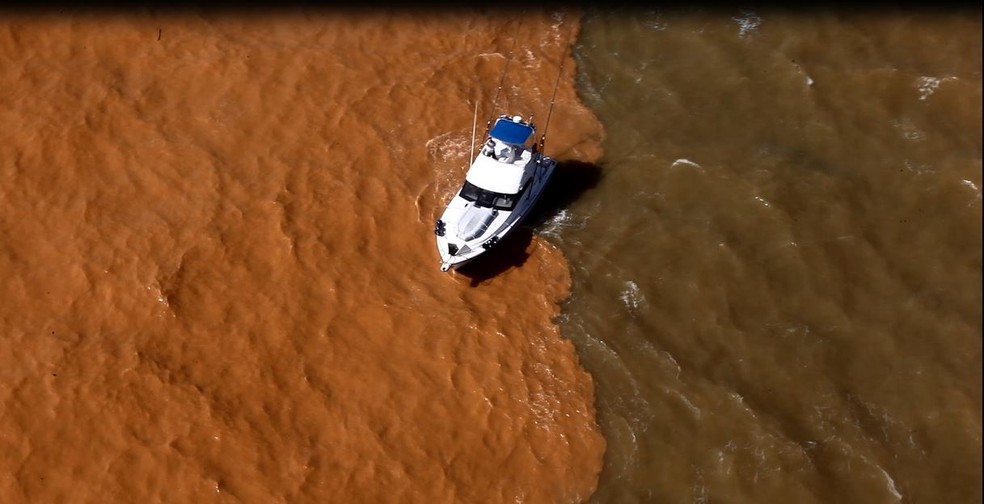 Barco passa por divisa entre lama e mar, em Regência, Linhares, Espírito Santo, em 2015. — Foto: Marcello Lourenço/ Arquivo Pessoal