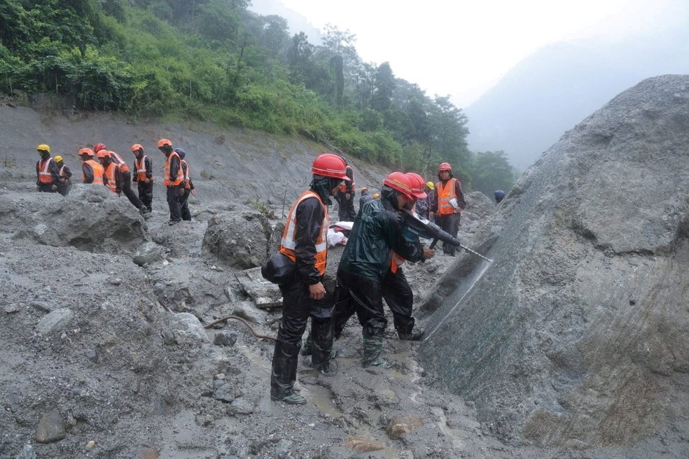 Equipes de resgate participando de uma operação de salvamento perto do túnel do Projeto Hidrelétrico Trishuli 3A, no Nepal — Foto: Nepal Prime Minister's Office via Reuters