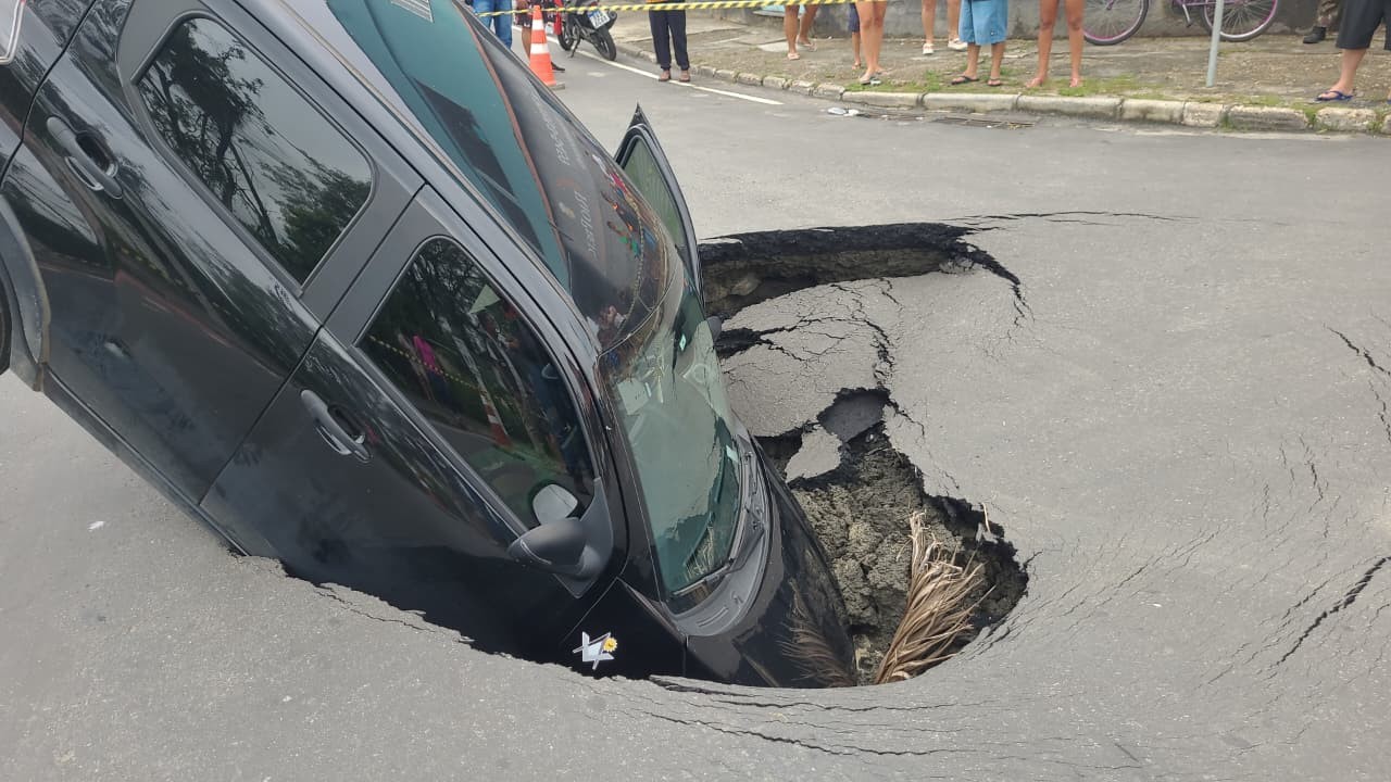 Asfalto cede e carro cai em cratera em Resende