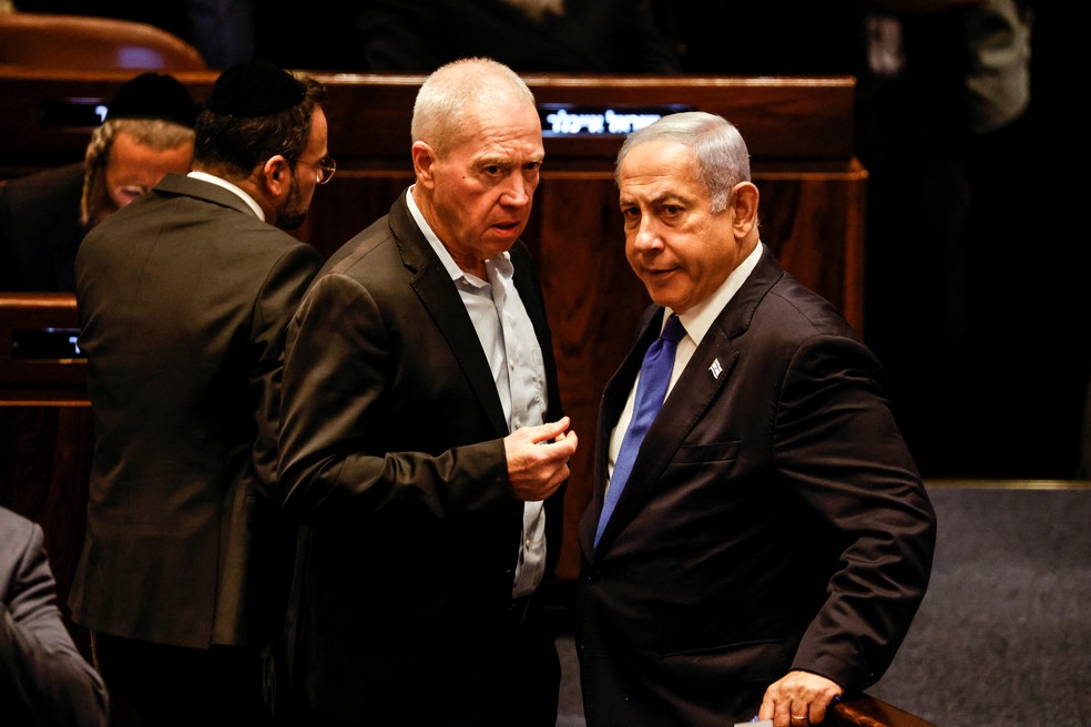 O ministro da Defesa de Israel, Yoav Gallant, fala com o primeiro-ministro Benjamin Netanyahu, durante sessão do Parlamento em 24 de julho de 2023. — Foto: Amir Cohen/REUTERS