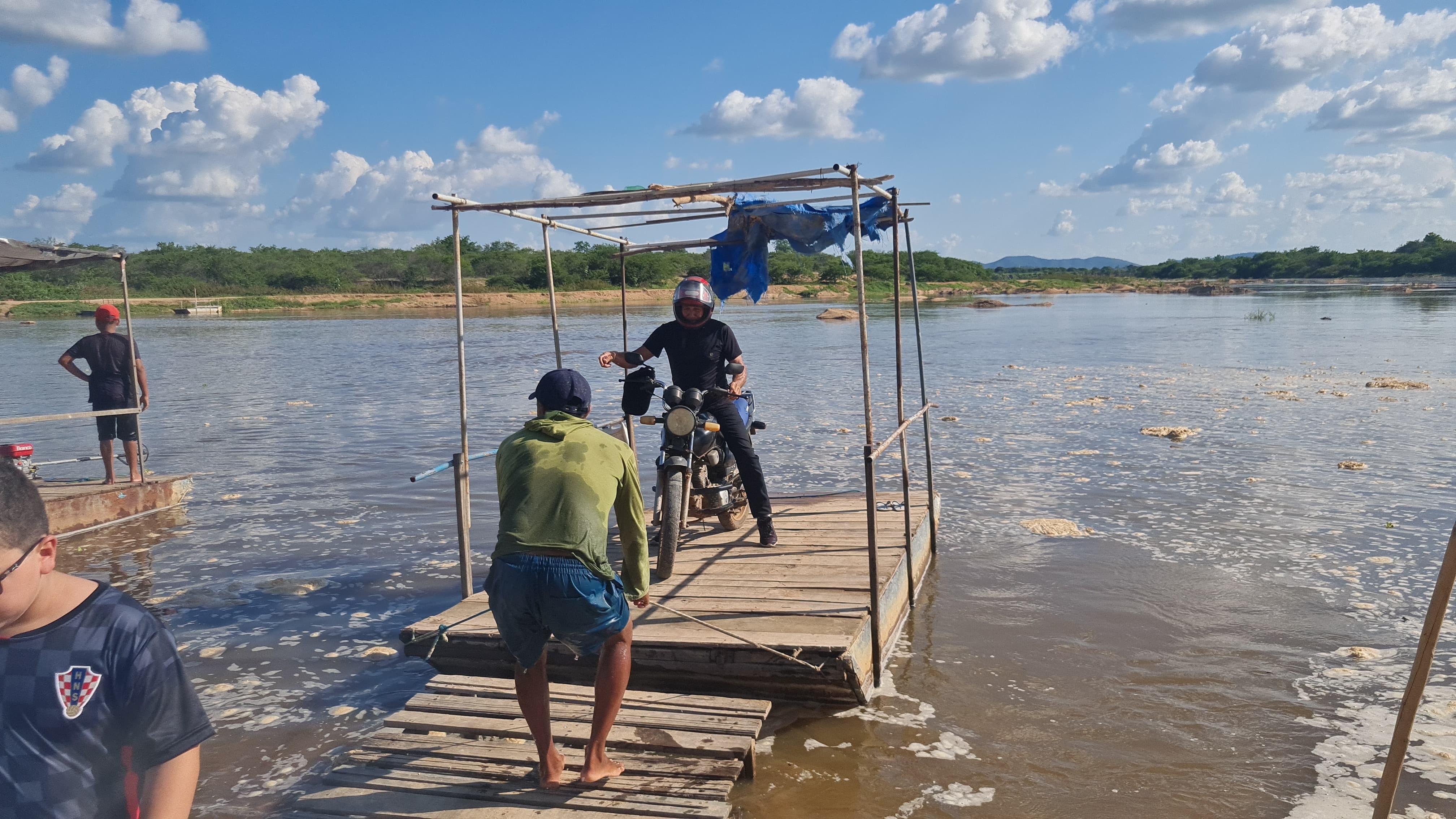 Moradores improvisam balsas para atravessar trecho de rio que encheu ...