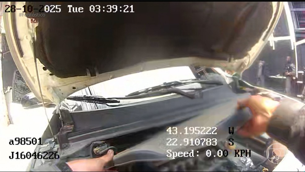 Policiais furtam peças de uma caminhonete abandonada na comunidade — Foto: Reprodução/TV Globo