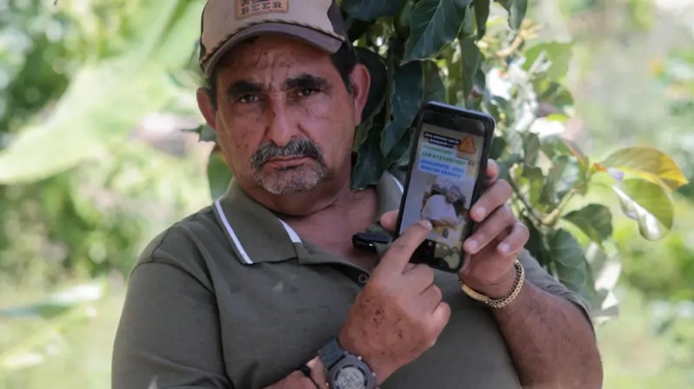 José Rincón mostra na tela do celular a foto do seu neto Abelardo Rincón, que voltava dos Estados Unidos, deportado no voo 164 — Foto: Nicole Kolster/BBC