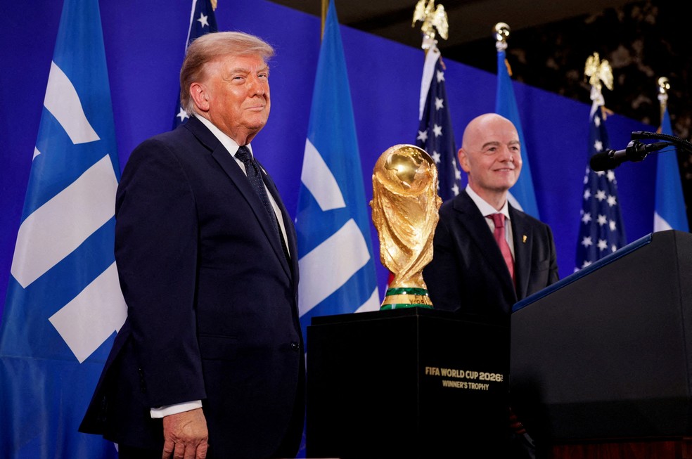 O presidente dos EUA, Donald Trump, e o presidente da FIFA, Gianni Infantino, posam ao lado da taça da Copa do Mundo da FIFA durante uma recepção da FIFA na Trump Tower, em Nova York, EUA, em 17 de julho de 2026 — Foto: REUTERS/Evan Vucci