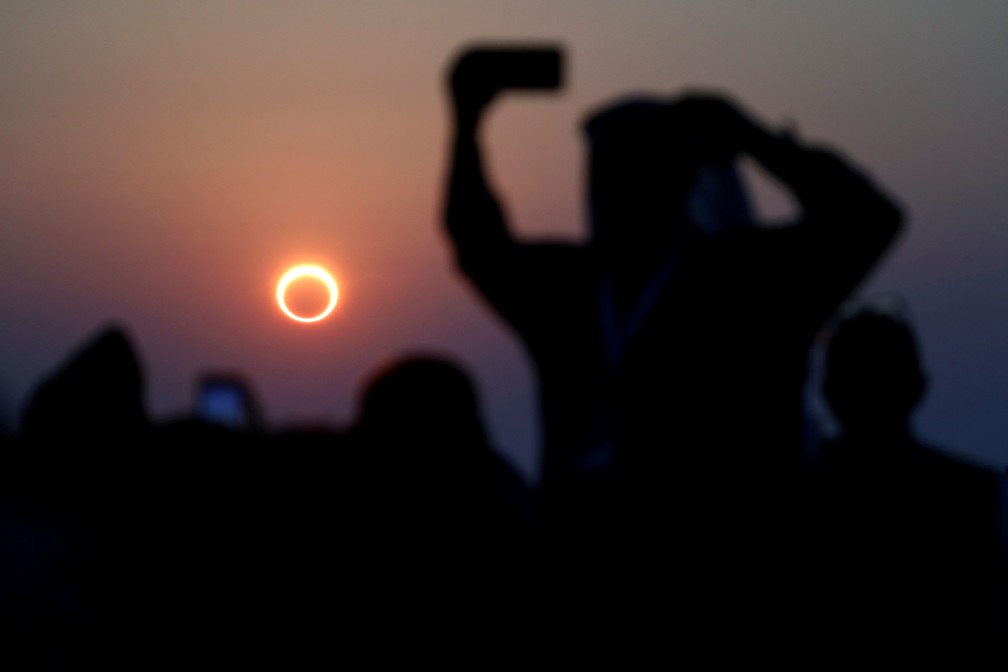 Pessoas tiram fotos com seus smartphones enquanto monitoram o eclipse solar anular na Ar&aacute;bia Saudita &mdash; Foto: REUTERS/Hamad I Mohammed