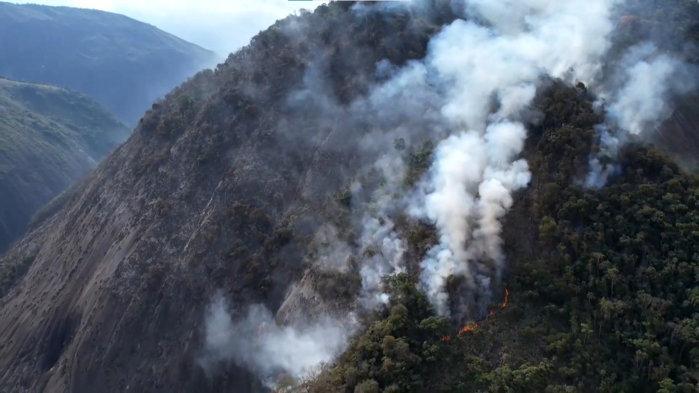 Bombeiros tentam controlar incêndio em vegetação causado por caminhão que pegou fogo há 2 dias