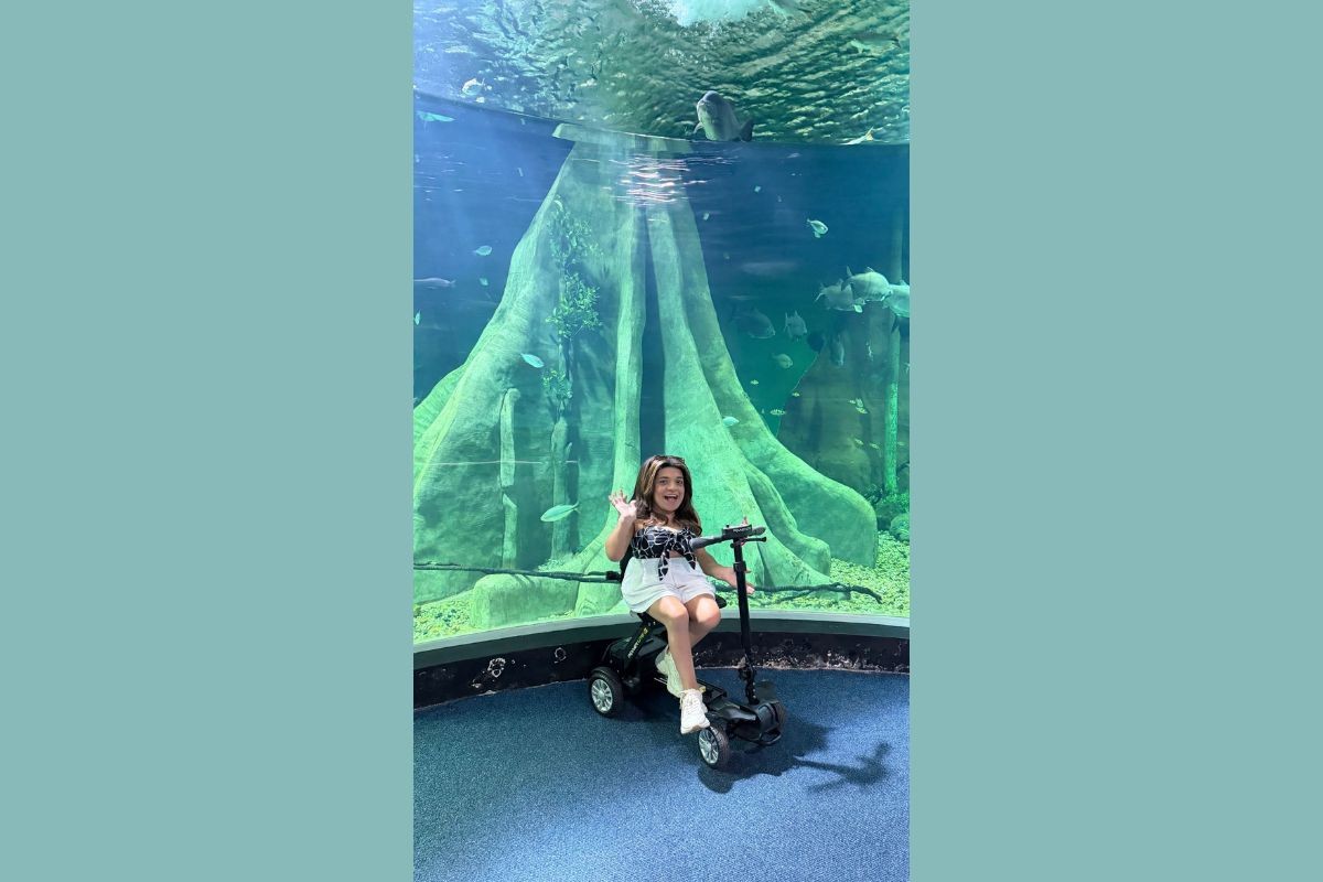 Pequena Lô encosta em pele de cobra durante visita ao maior aquário de água doce do mundo