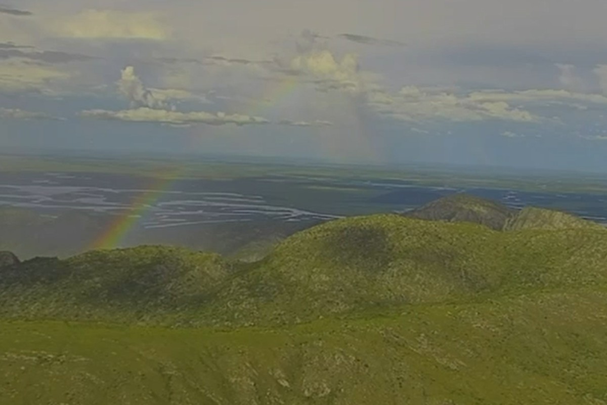 Arco-íris colore céu nublado no alto de santuário intocável no Pantanal; vídeo