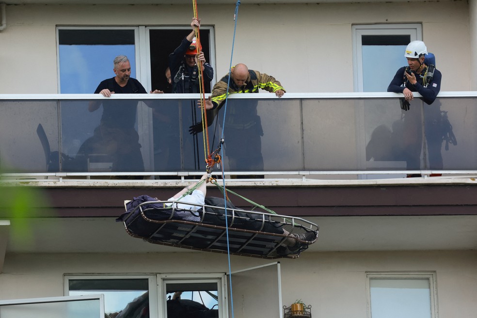 Bombeiros evacuam moradores de prédio na Antuérpia, na Bélgica, após incêndio em 1º de julho de 2026. — Foto: REUTERS/Yves Herman