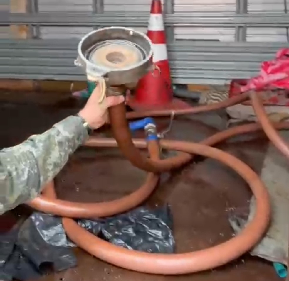 Mangueira funcionava como mecanismo para tirar o combustível dos caminhões-tanque — Foto: Polícia Ambiental