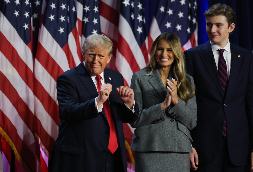 Donald Trump dança acompanhado da esposa Melania Trump e do filho Barron Trump, em 2025.  — Foto: Carlos Barria/Reuters