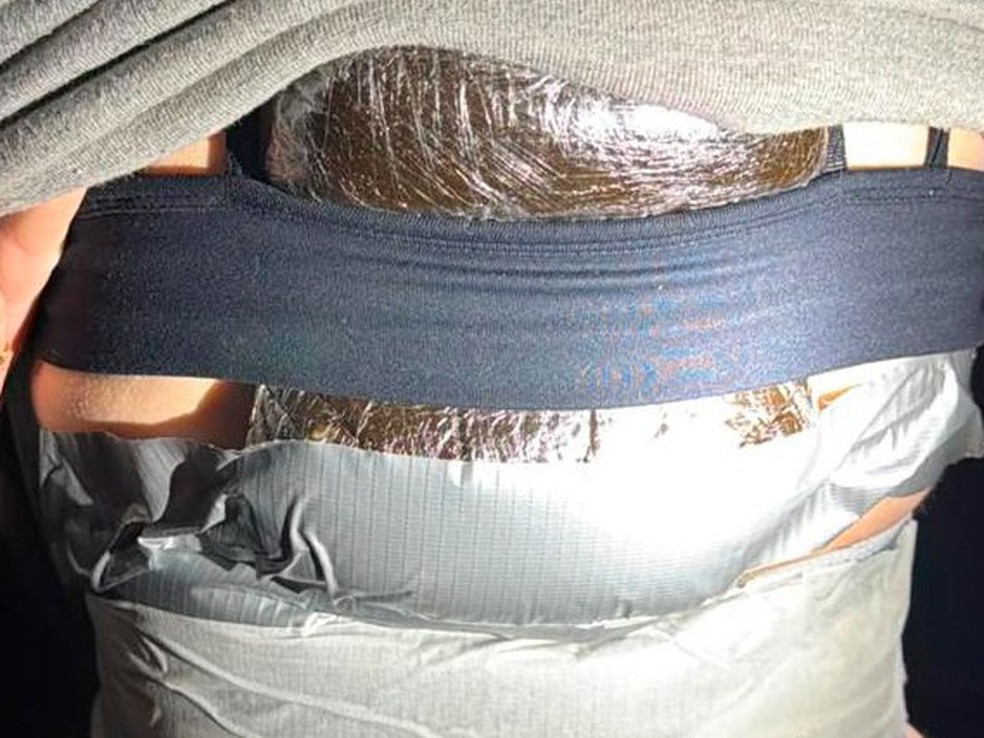Jovem de 19 anos foi pega transportando quase 4,5 kg de drogas coladas nas próprias pernas — Foto: Receita Federal