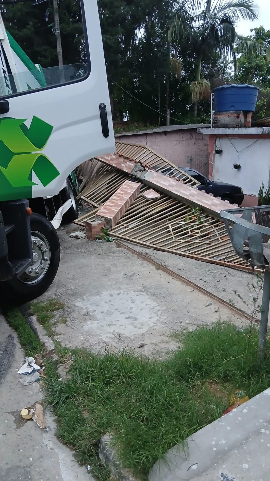 Caminhão de coleta de lixo bate na garagem de casas em Poá