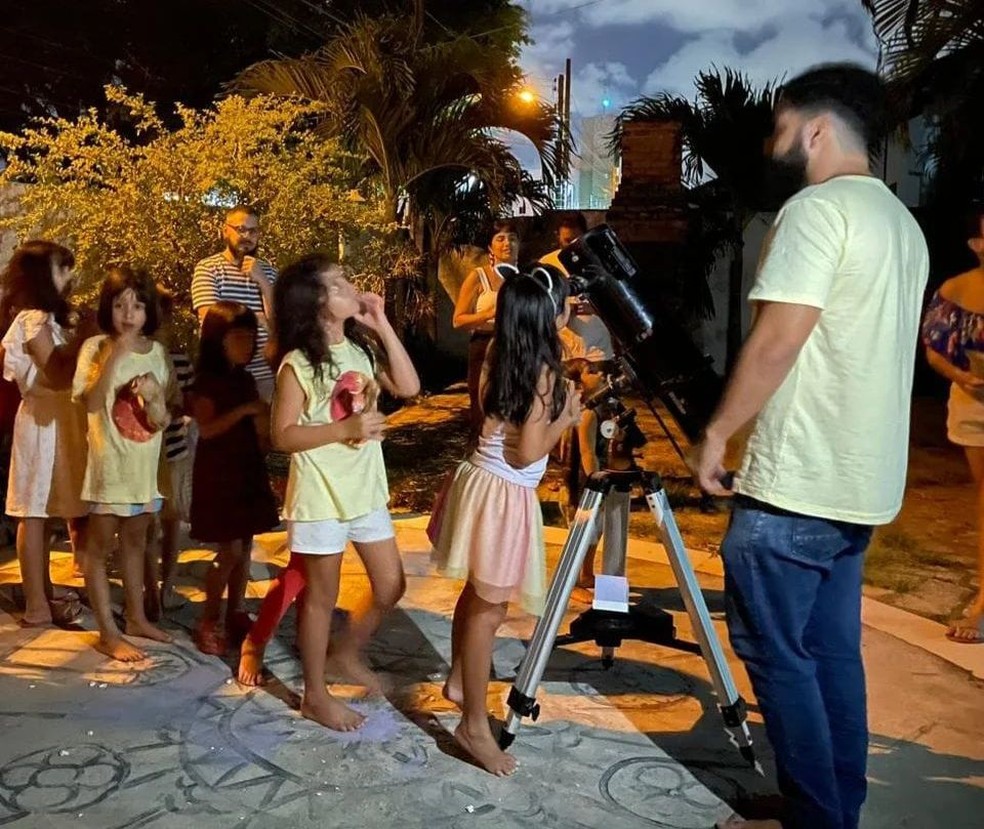 Professor e crianças analisando juntos imagens do telescópio — Foto: Welton Dionisio/Arquivo Pessoal