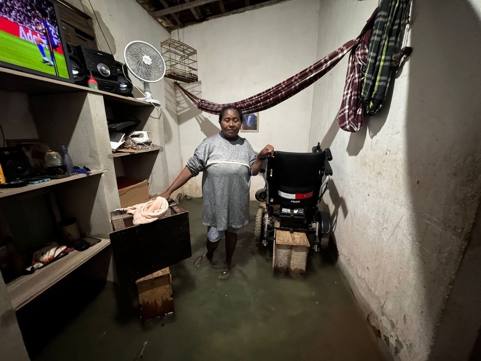 Dona de casa Zélia Targino, colocou a cadeira de rodas elétrica da filha sobre outros móveis para proteger equipamento da água — Foto: Vinícius Marinho/Inter TV Cabugi
