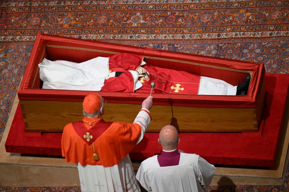 Cardeal Kevin Farell asperge água benta sobre o corpo do papa Francisco, em 25 de abril de 2025 — Foto: Vaticano