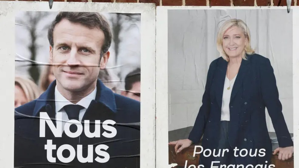 Cartazes oficiais da campanha dos dois candidatos às eleições presidenciais francesas em 2022 — Foto: Reuters