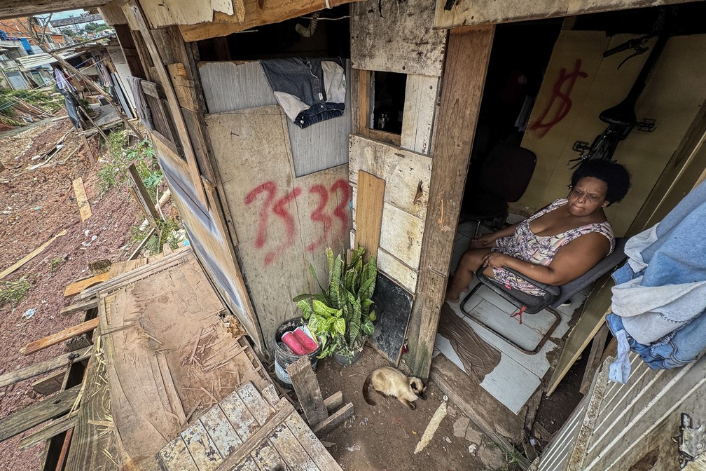 Há mais de dois meses, Débora observa o exterior sem conseguir sair de casa na comunidade Jerusalém, na Zona Sul de São Paulo. Com dificuldade de locomoção, ela não consegue passar pelo que sobrou do caminho à beira do barranco — Foto: Fábio Tito/g1