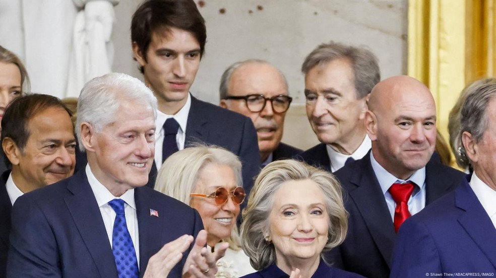O chefe da LVMH, Bernard Arnault (no fundo à direita, sem óculos e olhando para a esquerda), estava na posse de Trump, mas amizade entre ambos não o protegeu das tarifas — Foto: Shawn Thew/ABACAPRESS/IMAGO via DW