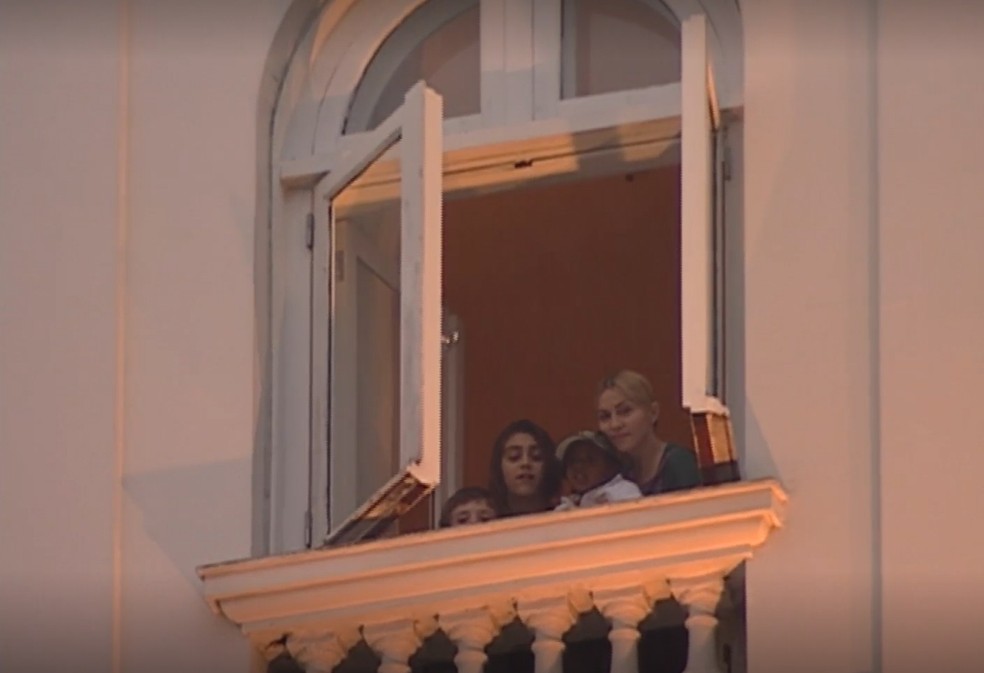 Madonna e os filhos na janela de um dos apartamentos do Copacabana Palace — Foto: Reprodução/ TV Globo