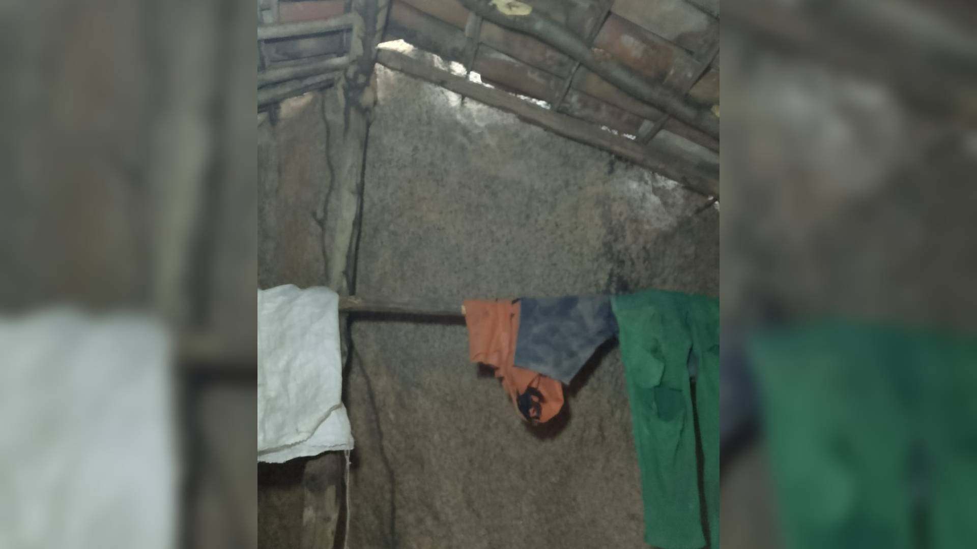 Interior da 'casinha' construída entre duas rochas no CE: local tem duas paredes de pedra; troncos usados na obra fazem as vezes de cabide — Foto: Reprodução