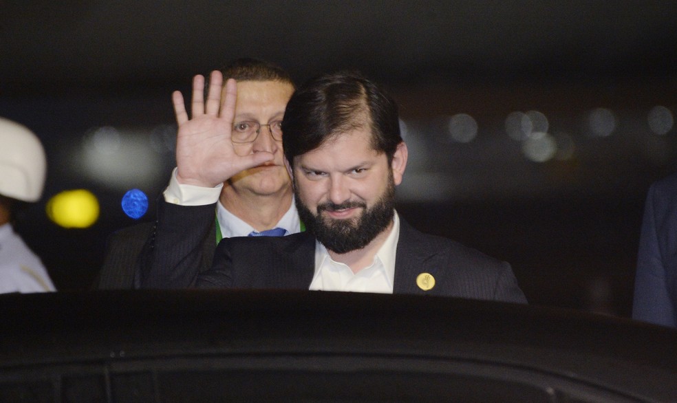 Gabriel Boric, presidente do Chile, acena durante desembarque no aeroporto do Galeão para participar do G20 na noite de sábado (16) — Foto: Alex Ferro/G20