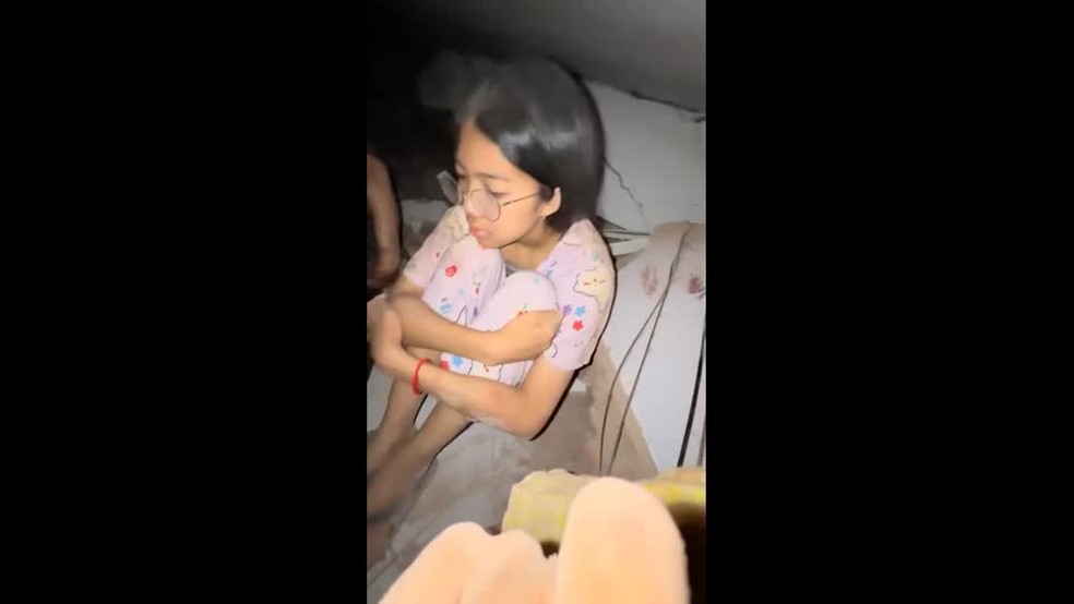 Menina presa nos escombros em Mianmar, após terremoto, aguarda socorro — Foto: U NAUNG via REUTERS