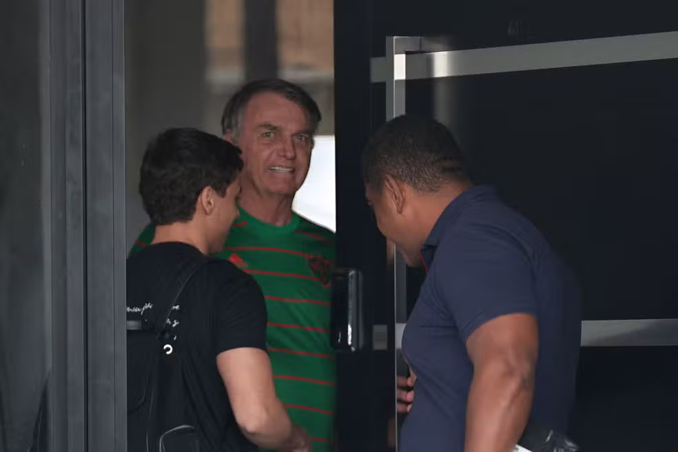 O ex-presidente do Brasil, Jair Bolsonaro, aparece na porta de sua casa, durante sua prisão domiciliar, em Brasília, Brasil, em 21 de novembro — Foto: Mateus Bonomi/Reuters