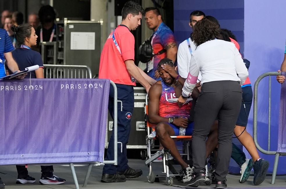 Noah Lyles recebe ajuda para sair da pista após a final dos 200 metros — Foto: Matthias Schrader/AP