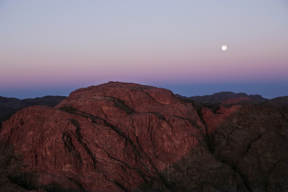 O sol nasce enquanto a lua se põe a partir da vista do topo do Monte Sinai ou 'Monte Moisés' em Santa Catarina, na península do Sinai, Egito, sexta-feira, 6 de outubro de 2017. — Foto: Reprodução AP Photo - Nariman El-Mofty