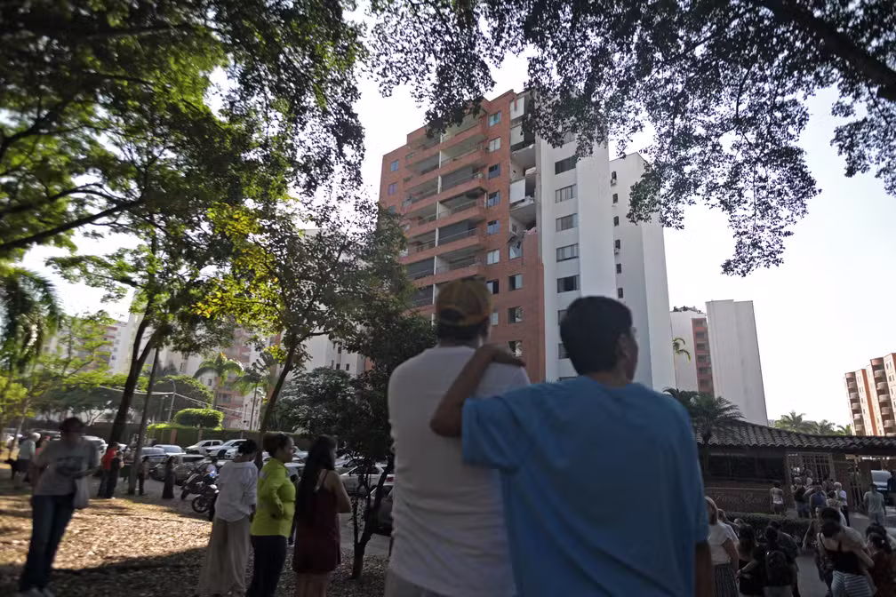 Moradores olham para pr�dio em C�li, na Col�mbia, ap�s evacuarem por conta de terremoto de magnitude 7,4 em 10 de agosto de 2026. � Foto: Joaquin Sarmiento/AFP